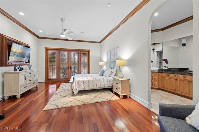 bedroom with light wood-style floors, access to outside, arched walkways, and baseboards