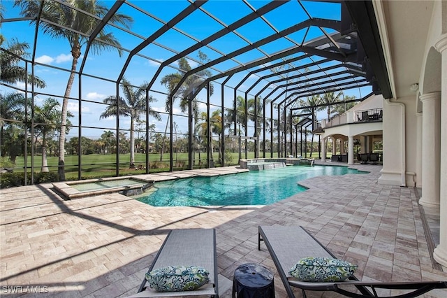 view of swimming pool featuring a patio area, a lanai, and a pool with connected hot tub