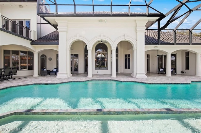 view of swimming pool with a patio, glass enclosure, and a pool with connected hot tub