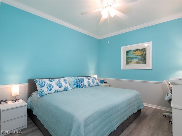 bedroom featuring hardwood / wood-style floors, ceiling fan, and crown molding