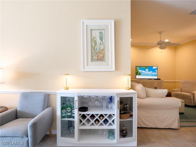 sitting room with tile patterned floors, crown molding, and ceiling fan