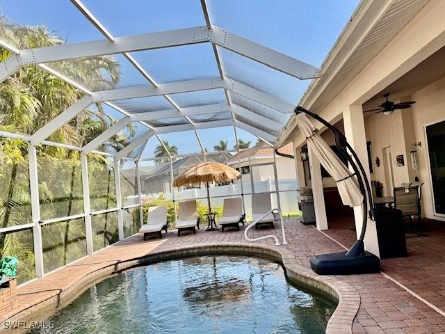 view of pool with a lanai, ceiling fan, and a patio area