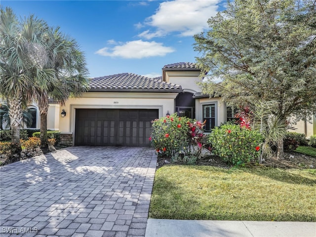 mediterranean / spanish house featuring a garage and a front lawn