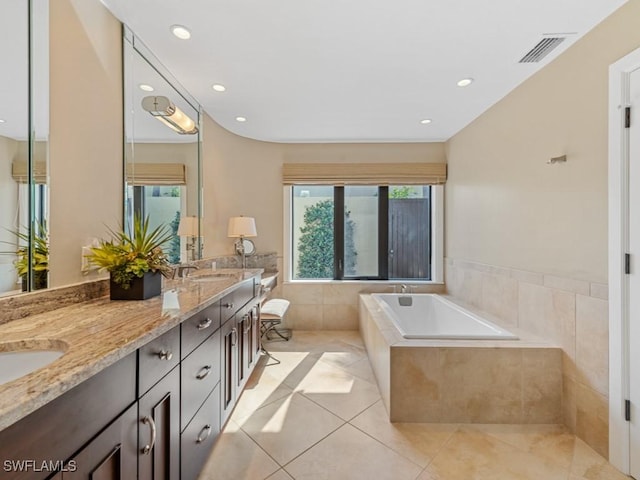 bathroom with vanity, tiled bath, and tile patterned floors