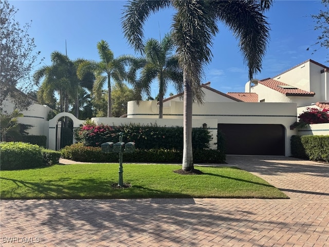 view of front of property with a garage and a front lawn