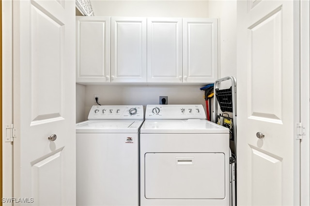 laundry area featuring washing machine and dryer and cabinets