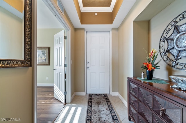 interior space with light tile patterned flooring and a tray ceiling