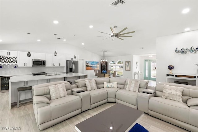 living room featuring vaulted ceiling, recessed lighting, wine cooler, visible vents, and a ceiling fan