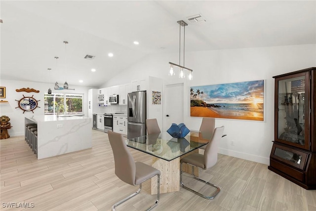 dining space with baseboards, vaulted ceiling, and visible vents