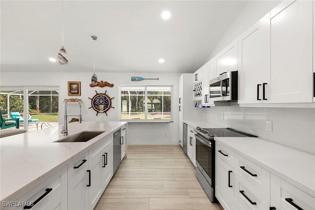 kitchen featuring backsplash, a sink, stainless steel appliances, white cabinets, and recessed lighting