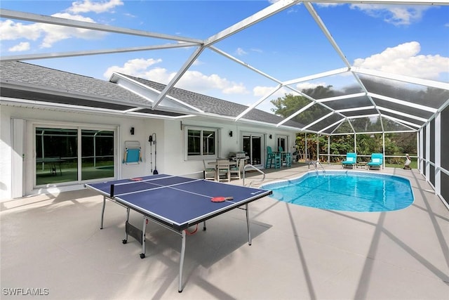 outdoor pool with a lanai and a patio area