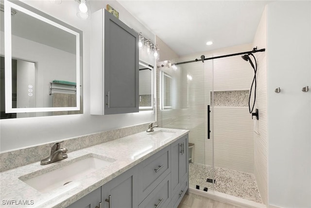 bathroom with double vanity, a sink, and a stall shower