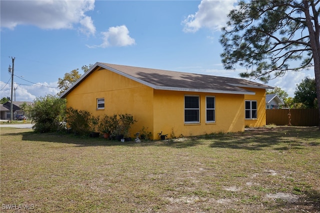 view of side of home with a yard