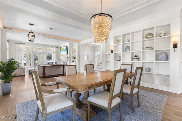 dining space with wood finished floors, french doors, stairway, an inviting chandelier, and crown molding