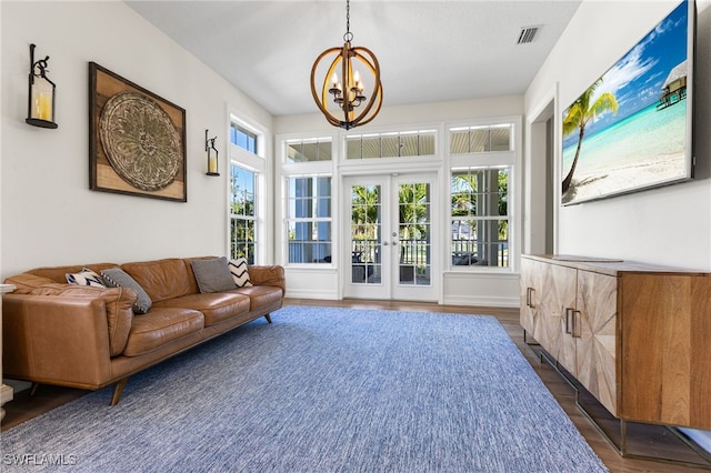 interior space with baseboards, visible vents, dark wood-style floors, french doors, and a notable chandelier