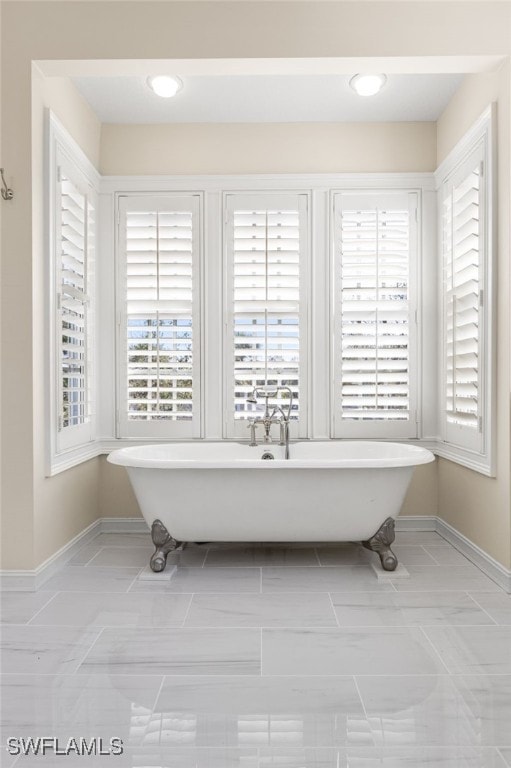 details featuring a soaking tub and baseboards