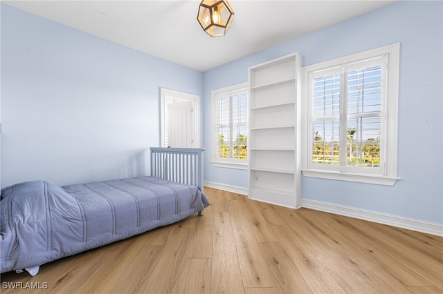 bedroom featuring light wood-style flooring and baseboards