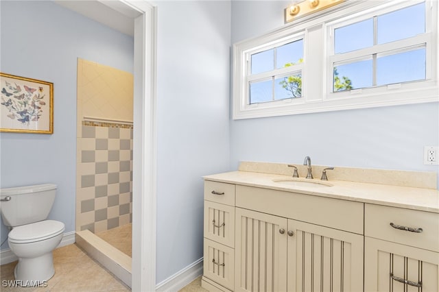 full bathroom featuring a stall shower, baseboards, vanity, and toilet