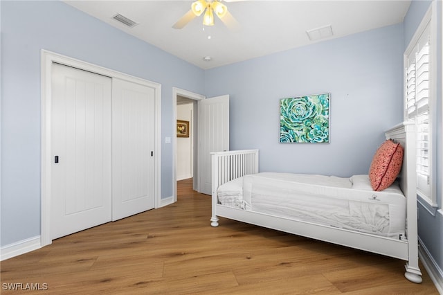 bedroom featuring light wood-style floors, a closet, visible vents, and baseboards