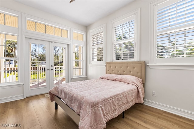 bedroom featuring access to outside, french doors, wood finished floors, and baseboards