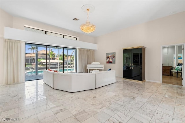 unfurnished living room with a notable chandelier and a high ceiling