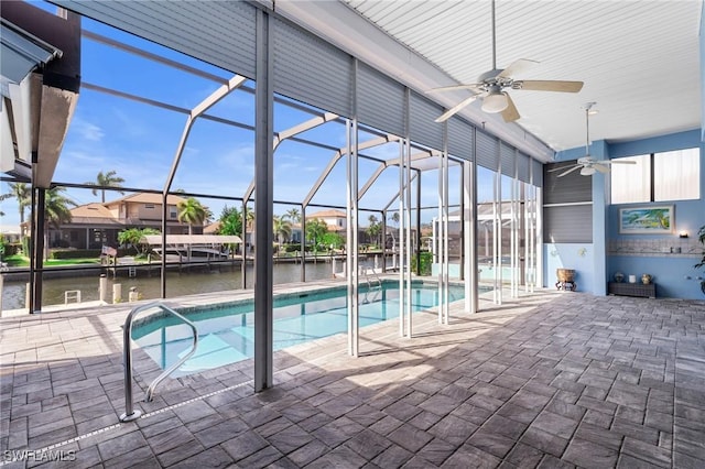 view of pool featuring a water view, ceiling fan, a lanai, and a patio area