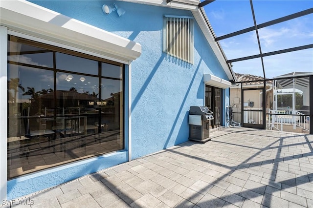 view of patio / terrace featuring a grill and glass enclosure