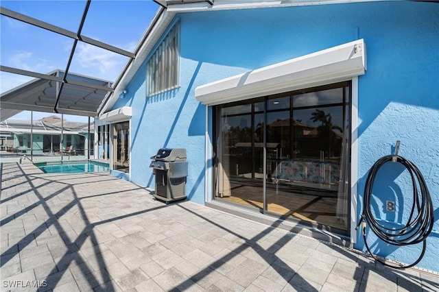 rear view of house featuring glass enclosure and a patio area