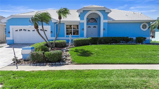 view of front of property with a garage and a front lawn