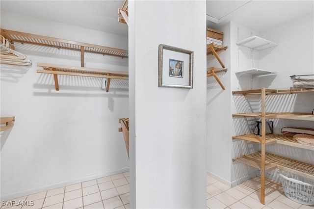 walk in closet with light tile patterned floors