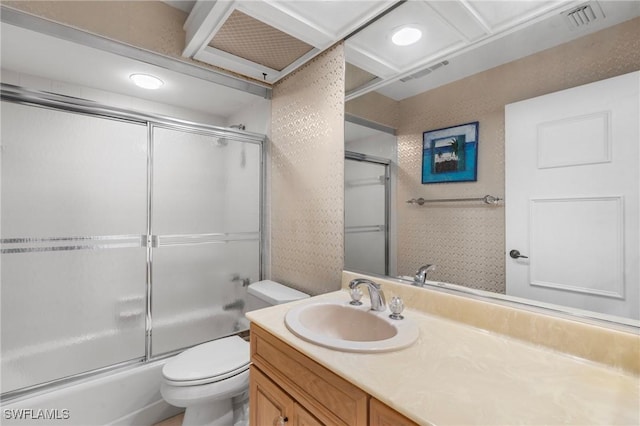 full bathroom featuring vanity, combined bath / shower with glass door, and toilet