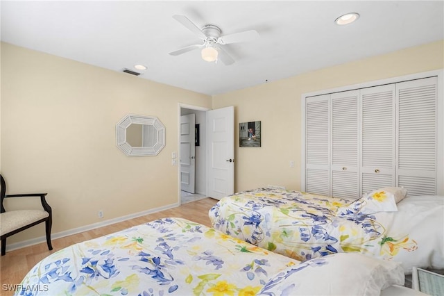 bedroom with ceiling fan, light wood-type flooring, and a closet