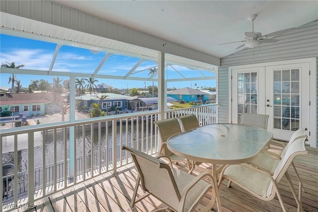 sunroom / solarium with a residential view, french doors, and ceiling fan