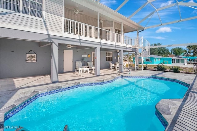 outdoor pool featuring a lanai, a patio area, a ceiling fan, and stairway