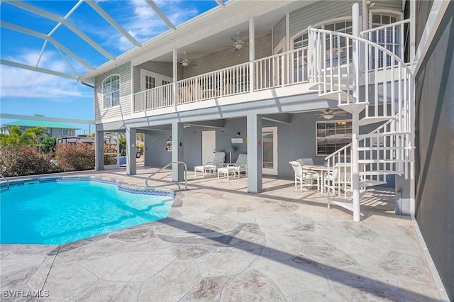 pool featuring a lanai, a patio, a ceiling fan, and stairs
