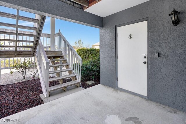 entrance to property featuring a patio and stucco siding