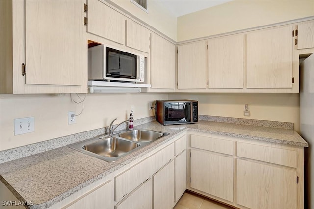 kitchen with a sink, visible vents, light countertops, and light tile patterned floors