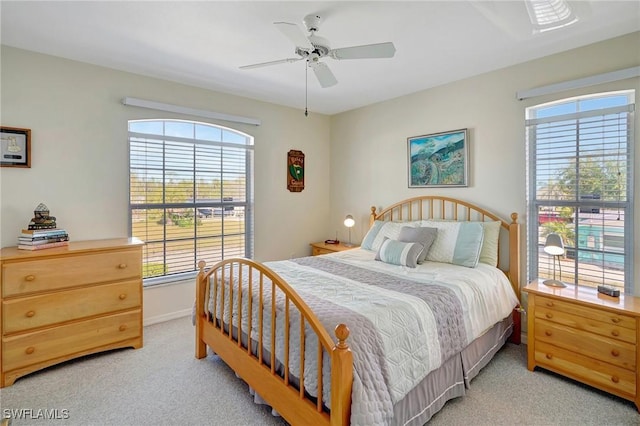 bedroom with light carpet, baseboards, and ceiling fan
