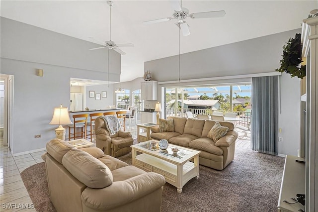living room featuring high vaulted ceiling, ceiling fan, baseboards, and a wealth of natural light