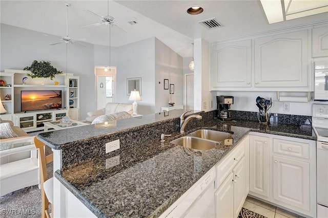 kitchen with open floor plan, a peninsula, a ceiling fan, visible vents, and a sink