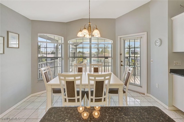 dining area with baseboards, a notable chandelier, and light tile patterned flooring