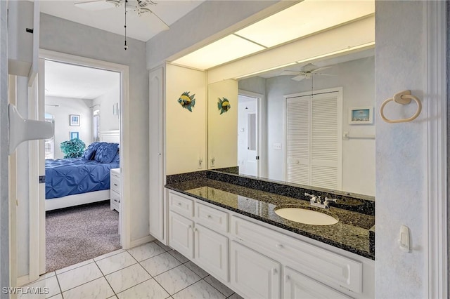 ensuite bathroom featuring baseboards, a ceiling fan, connected bathroom, and vanity