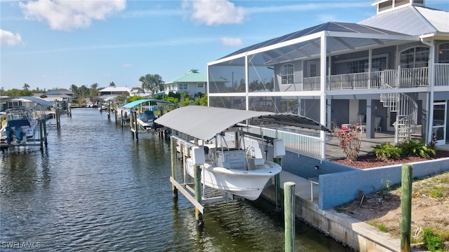 view of dock with a water view, glass enclosure, and boat lift