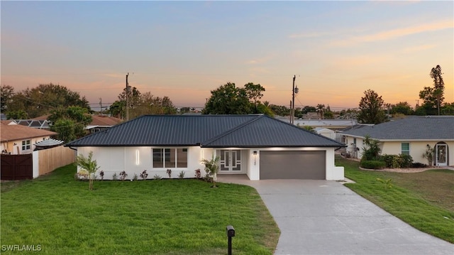 single story home featuring metal roof, concrete driveway, and a front lawn