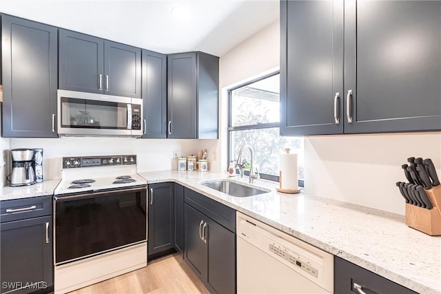 kitchen with range with electric cooktop, dishwasher, sink, light stone counters, and light hardwood / wood-style floors