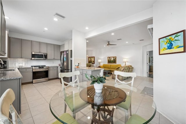 tiled dining area featuring ceiling fan and sink