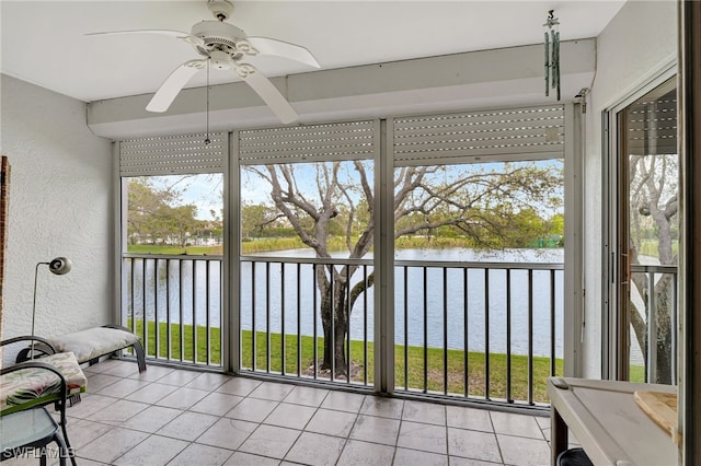 unfurnished sunroom with a water view and a ceiling fan