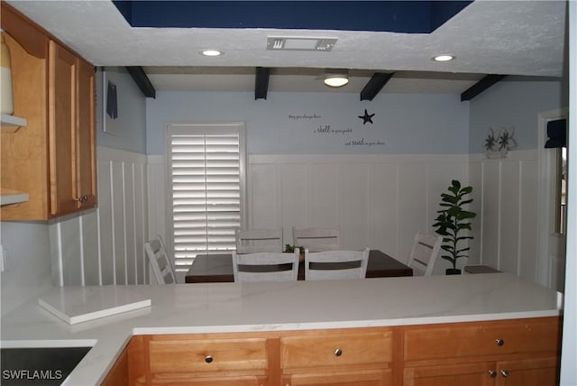 kitchen featuring beamed ceiling and a textured ceiling