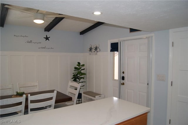 kitchen featuring a textured ceiling and vaulted ceiling with beams