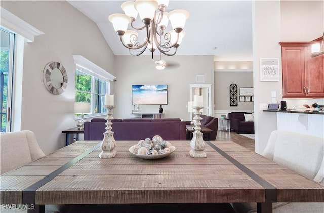 dining area with a chandelier and vaulted ceiling